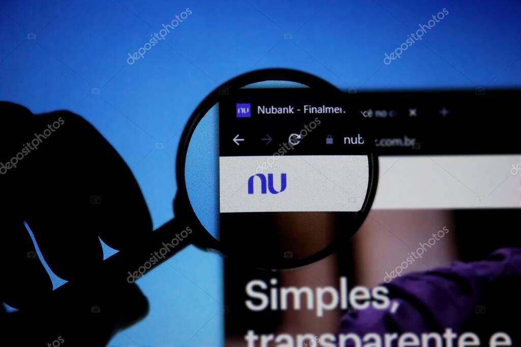 Bahia, Brazil - July 8, 2021: Homepage of Nubank Website magnified on logo with magnifying glass. Nubank is a Brazilian digital bank.
