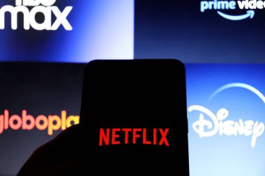 Bahia, Brezilya - 26 Temmuz 2021: Arkaplanda Globoplay, Disney +, HBO Max ve Prime Video logoları sergilenen akıllı telefon ekranında Netflix uygulaması. Akıcı uygulamalar. 