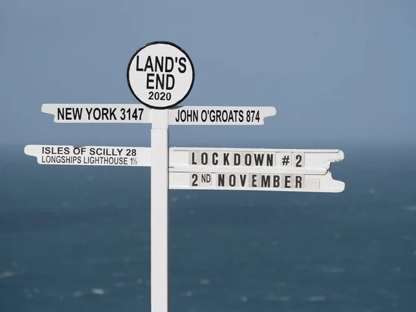 英国のランド エンドの象徴的な看板には 英国コロナウイルスの流行制限の現在の問題を示す Lockdown が書かれています 背景の海 — ストック写真
