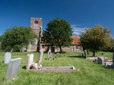Tolleshunt Major - Essex - İngiltere-14 Haziran 2021 - St. Nicholas Kilisesi çimenli alanda ağaçlar ve mezar taşlarıyla birlikte güneşli mavi bir günde