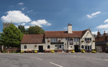 Goldhanger-Essex-İngiltere-14 Haziran 2021 - Goldhanger köyündeki Chequers Inn. Arka planda kilise kulesi olan yol kenarı. Mavi gökyüzü ve beyaz bulutlu yaz günü..
