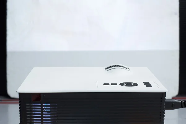 Closeup of projector for presentation with blank screen in front — Stock Photo, Image