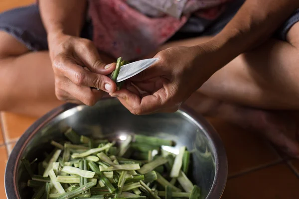 Bir bıçak ve soyulmuş horseradish tutan bir el sormak.