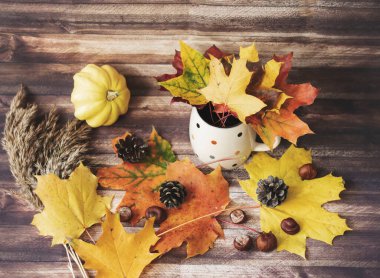 Yapraklar, koniler, fincanlar, süveterler ile sonbahar dekorasyonu