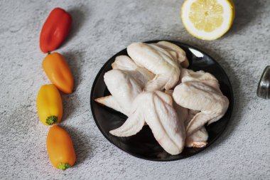 Gri arka planda çiğ tavuk kanadı eti