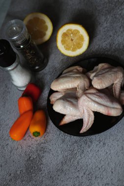 Gri arka planda çiğ tavuk kanadı eti