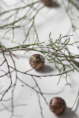 Yeşil dallar beyaz arka planda yatar. Ve yakınlarda mumlar ve fenerler var.