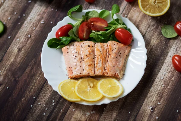Limonlu somon balığı ve diğer sebzeler. Tabakta somon