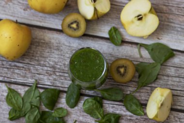 Bir bardak kivi, ıspanak ve elma püresi. Sağlık içeceği. Elma, keten tohumu, ıspanak, kivi, muz yakınlarda..