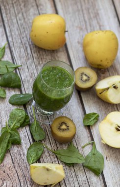 Bir bardak kivi, ıspanak ve elma püresi. Sağlık içeceği. Elma, keten tohumu, ıspanak, kivi, muz yakınlarda..