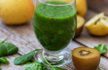 Bir bardak kivi, ıspanak ve elma püresi. Sağlık içeceği. Elma, keten tohumu, ıspanak, kivi, muz yakınlarda..