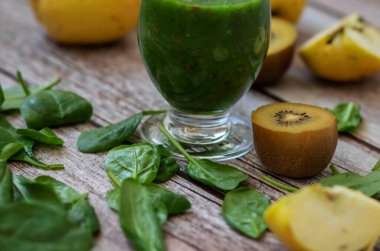 Bir bardak kivi, ıspanak ve elma püresi. Sağlık içeceği. Elma, keten tohumu, ıspanak, kivi, muz yakınlarda..