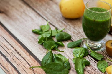 Bir bardak kivi, ıspanak ve elma püresi. Sağlık içeceği. Elma, keten tohumu, ıspanak, kivi, muz yakınlarda..