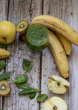 Bir bardak kivi, ıspanak ve elma püresi. Sağlık içeceği. Elma, keten tohumu, ıspanak, kivi, muz yakınlarda..