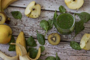 Bir bardak kivi, ıspanak ve elma püresi. Sağlık içeceği. Elma, keten tohumu, ıspanak, kivi, muz yakınlarda..