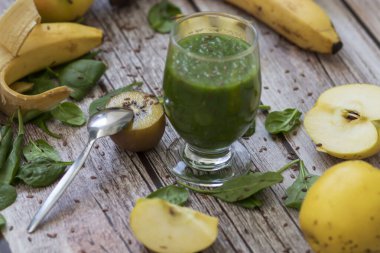 Bir bardak kivi, ıspanak ve elma püresi. Sağlık içeceği. Elma, keten tohumu, ıspanak, kivi, muz yakınlarda..