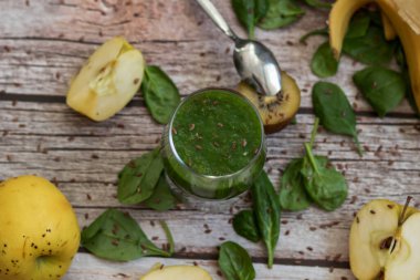 Bir bardak kivi, ıspanak ve elma püresi. Sağlık içeceği. Elma, keten tohumu, ıspanak, kivi, muz yakınlarda..