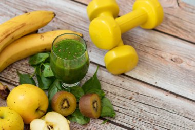 Bir bardak kivi, ıspanak ve elma püresi. Sağlık içeceği. Elma, keten tohumu, ıspanak, kivi, muz yakınlarda..