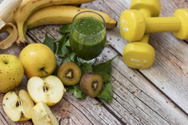 Bir bardak kivi, ıspanak ve elma püresi. Sağlık içeceği. Elma, keten tohumu, ıspanak, kivi, muz yakınlarda..