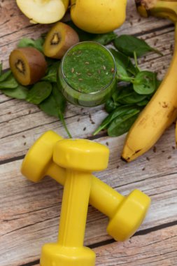 Bir bardak kivi, ıspanak ve elma püresi. Sağlık içeceği. Elma, keten tohumu, ıspanak, kivi, muz yakınlarda..