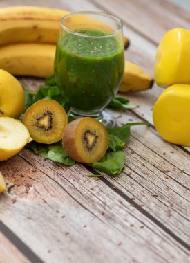 Bir bardak kivi, ıspanak ve elma püresi. Sağlık içeceği. Elma, keten tohumu, ıspanak, kivi, muz yakınlarda..