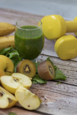 Bir bardak kivi, ıspanak ve elma püresi. Sağlık içeceği. Elma, keten tohumu, ıspanak, kivi, muz yakınlarda..