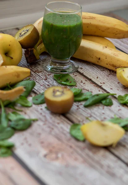 Bir bardak kivi, ıspanak ve elma püresi. Sağlık içeceği. Elma, keten tohumu, ıspanak, kivi, muz yakınlarda..