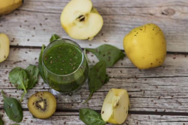 Bir bardak kivi, ıspanak ve elma püresi. Sağlık içeceği. Elma, keten tohumu, ıspanak, kivi, muz yakınlarda..