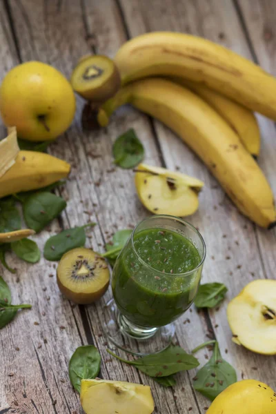 Bir bardak kivi, ıspanak ve elma püresi. Sağlık içeceği. Elma, keten tohumu, ıspanak, kivi, muz yakınlarda..