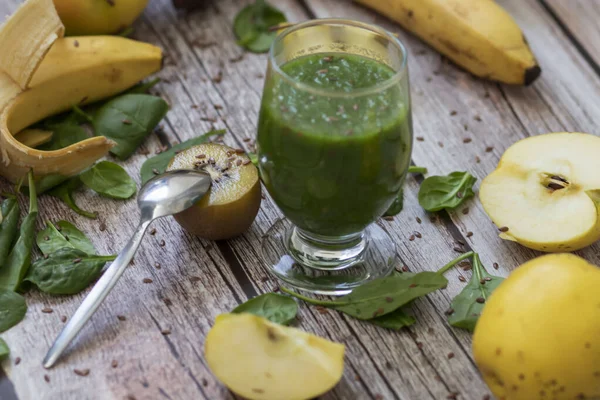 Bir bardak kivi, ıspanak ve elma püresi. Sağlık içeceği. Elma, keten tohumu, ıspanak, kivi, muz yakınlarda..
