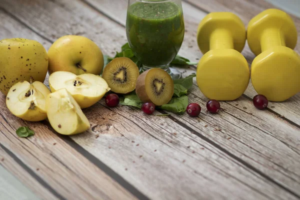 A glass of kiwi, spinach and apple smoothie. Health drink. Apples, flax seeds, spinach, kiwi, bananas lie nearby.