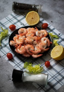 Hazır karidesler siyah tabakta.