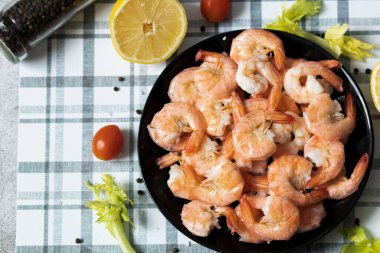 Hazır karidesler siyah tabakta.