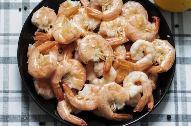 Hazır karidesler siyah tabakta.