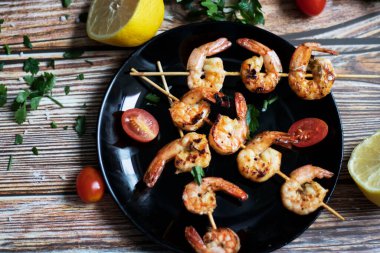 Tavada karides şiş, yağda kızartılmış ve baharatlı. Bunların hepsi masanın üzerinde. Yakınlarda bir tabak karides şalgamı var.