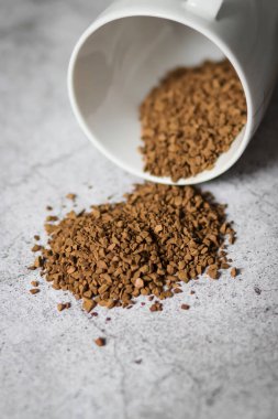 Gri arka planda beyaz fincanlı anlık kahve.