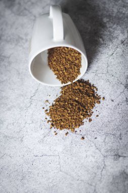 Gri arka planda beyaz fincanlı anlık kahve.