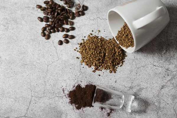 Instant coffee, coffee beans and ground coffee.All this on a gray background