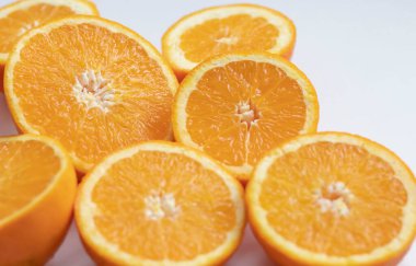 Portakal yarımları masanın üstünde. Gri ve beyaz bir arkaplanda.