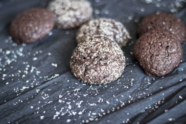 Hindistan cevizli çikolatalı kurabiyeler. Siyah ve gri bir arkaplanda uzan.