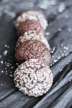 Hindistan cevizli çikolatalı kurabiyeler. Siyah ve gri bir arkaplanda uzan.