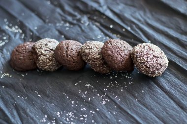 Hindistan cevizli çikolatalı kurabiyeler. Siyah ve gri bir arkaplanda uzan.