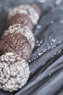 Hindistan cevizli çikolatalı kurabiyeler. Siyah ve gri bir arkaplanda uzan.