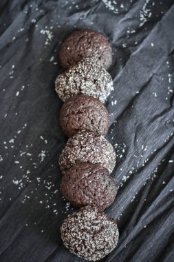 Hindistan cevizli çikolatalı kurabiyeler. Siyah ve gri bir arkaplanda uzan.