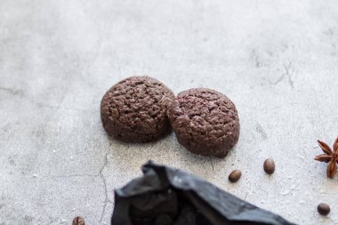 Hindistan cevizli çikolatalı kurabiyeler. Siyah ve gri bir arkaplanda uzan.