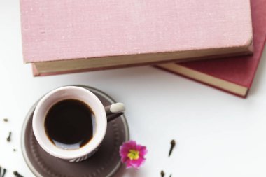 Pencerenin yanında güzel bir kahve fincanı var. Yakınlarda da kitaplar var.