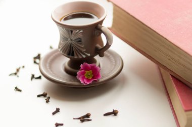 Pencerenin yanında güzel bir kahve fincanı var. Yakınlarda da kitaplar var.