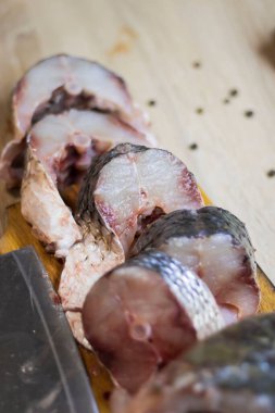 Fish. There is a raw fish cut into pieces on the kitchen board. And the whole thing.