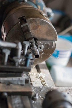 Metal endüstrisi: uçan kıvılcımları olan bir torna üzerinde çalışmak. Torna