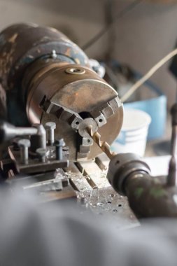 Metal endüstrisi: uçan kıvılcımları olan bir torna üzerinde çalışmak. Torna